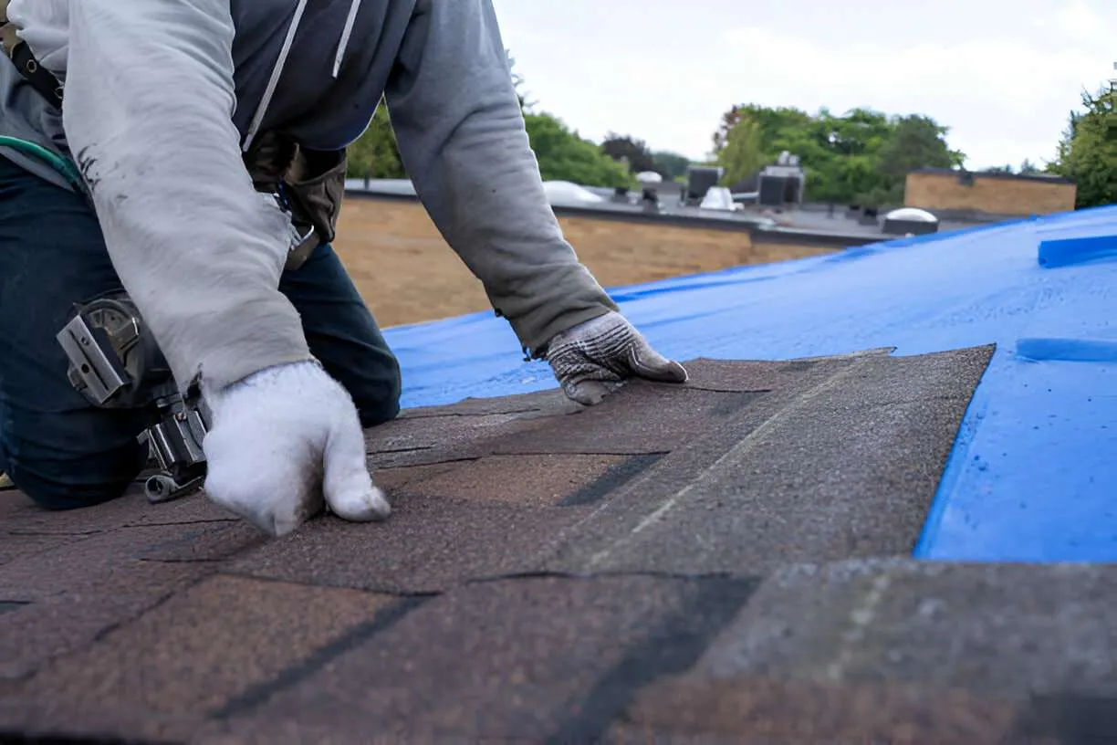 Roofer installing premium shingles on a residential roof
